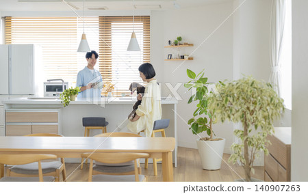 A man and woman in their 30s relaxing at home with a miniature dachshund: an image of life with a dog. 140907263