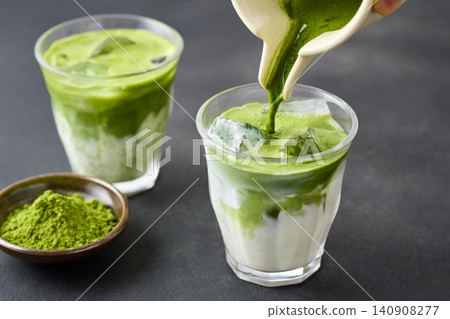 Pour the iced matcha latte into a glass. Pour the iced matcha latte into a glass. 140908277