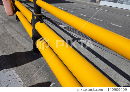 Bright Yellow Safety Barrier on Urban Roadside for Traffic Control and Pedestrian Safety Bright Yellow Safety Barrier on Urban Roadside for Traffic Control and Pedestrian Safety 140909409
