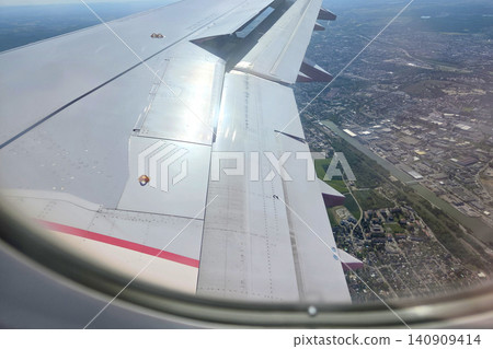 Aerial View from Airplane Window: Cityscape and Wing in Flight Aerial View from Airplane Window: Cityscape and Wing in Flight 140909414