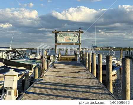 Vanderbilt's Wharf Sign on Dock With Boats Under Sunny Sky Vanderbilt's Wharf Sign on Dock With Boats Under Sunny Sky 140909653
