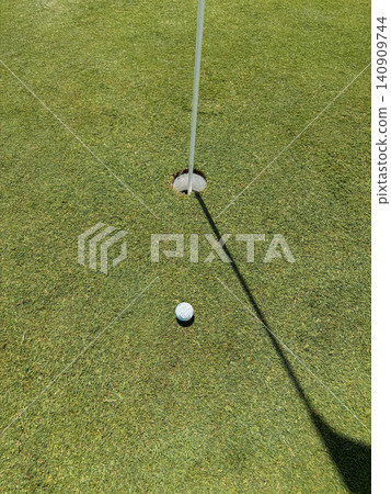 Golf Ball Near Hole on Green in Sunny Weather During the Game Golf Ball Near Hole on Green in Sunny Weather During the Game 140909744