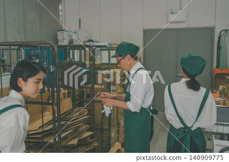 Male and female staff working in the back room of a supermarket Male and female staff working in the back room of a supermarket 140909775