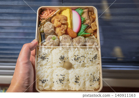 A bento box held in the hand on a train A bento box held in the hand on a train 140911163