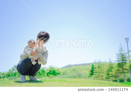 A mother holding a baby under the blue sky 140911174