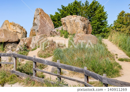 Rocks and plants along a sandy path in a park on a sunny day 140911269
