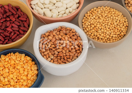 Variety of protein products for vegetarians. Types of beans, soy and peas in bowls. Nutrition balance. Place for text. Top view. Variety of protein products for vegetarians. Types of beans, soy and peas in bowls. Nutrition balance. Place for text. Top view. 140911334
