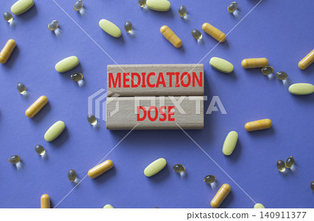 Medication dose symbol. Concept word Medication dose on wooden blocks. Beautiful purple background with pills. Medicine and Medication dose. Copy space Medication dose symbol. Concept word Medication dose on wooden blocks. Beautiful purple background with pills. Medicine and Medication dose. Copy space 140911377