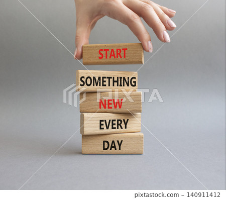 New symbol. Wooden blocks with words Start Something New Every Day. Businessman hand. Beautiful grey background. Business and New concept. Copy space New symbol. Wooden blocks with words Start Something New Every Day. Businessman hand. Beautiful grey background. Business and New concept. Copy space 140911412