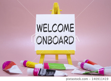 Welcome onboard symbol. Concept words Welcome onboard on wooden blocks. Beautiful pink background with paints and easel. Business and Welcome onboard concept. Copy space. Welcome onboard symbol. Concept words Welcome onboard on wooden blocks. Beautiful pink background with paints and easel. Business and Welcome onboard concept. Copy space. 140911419
