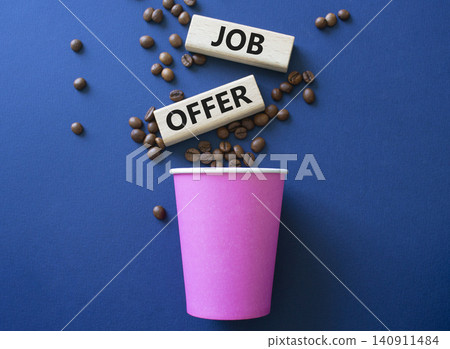 Job Offer symbol. Concept word Job Offer on wooden blocks. Beautiful dark blue background with coffee cup. Business and Job Offer concept. Copy space 140911484