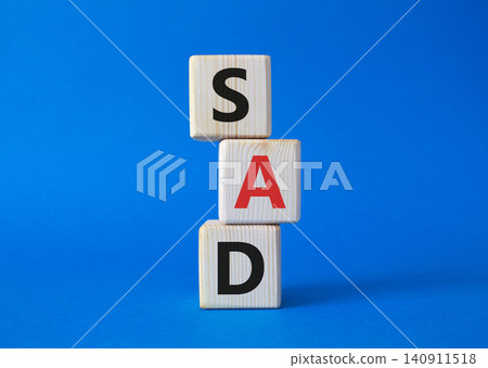 Sad symbol. Wooden cubes with words Sad. Beautiful blue background. Business and Sad concept. Copy space. Sad symbol. Wooden cubes with words Sad. Beautiful blue background. Business and Sad concept. Copy space. 140911518