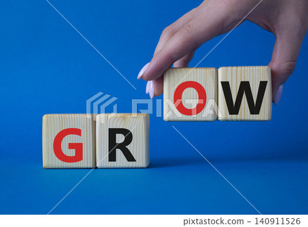 Grow symbol. Concept word Grow on wooden cubes. Beautiful blue background. Businessman hand. Business and Grow concept. Copy space. Grow symbol. Concept word Grow on wooden cubes. Beautiful blue background. Businessman hand. Business and Grow concept. Copy space. 140911526