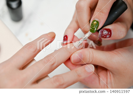 Close-up of a woman's hands showcasing beautiful autumn-themed gel nail art. Close-up of a woman's hands showcasing beautiful autumn-themed gel nail art. 140911597