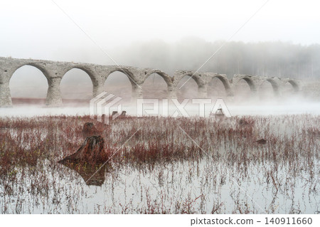 The Taushubetsu River Bridge in Kamishihoro Town, Hokkaido: A fantastical scene of an abandoned railway bridge enveloped in mist and autumn leaves. A tourist attraction. The Taushubetsu River Bridge in Kamishihoro Town, Hokkaido: A fantastical scene of an abandoned railway bridge enveloped in mist and autumn leaves. A tourist attraction. 140911660
