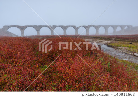 北海道上石幌町的陶州別川大橋:一座廢棄的鐵路橋被薄霧和秋葉籠罩,構成了一幅如夢似幻的景象。這裡是著名的旅遊景點。 北海道上石幌町的陶州別川大橋:一座廢棄的鐵路橋被薄霧和秋葉籠罩,構成了一幅如夢似幻的景象。這裡是著名的旅遊景點。 140911668