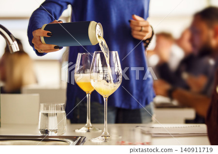 Woman Pouring Beer to Participant During Ale Type Tasting, Close up. Woman Pouring Beer to Participant During Ale Type Tasting, Close up. 140911719