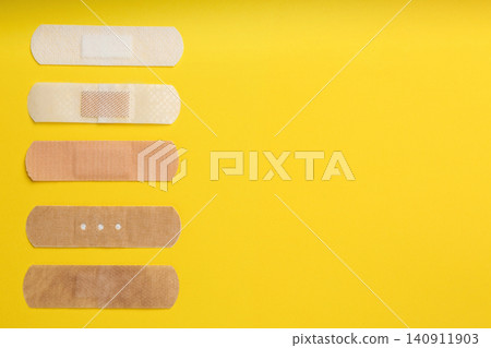 Different types of sticking plasters on yellow background, flat lay. Space for text Different types of sticking plasters on yellow background, flat lay. Space for text 140911903