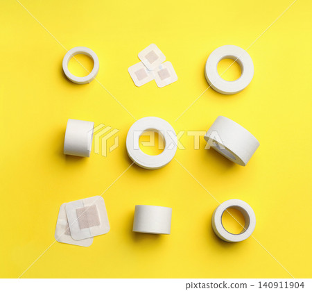 Different types of sticking plasters on yellow background, flat lay Different types of sticking plasters on yellow background, flat lay 140911904