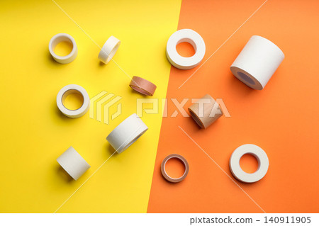 Sticking plaster rolls on color background, flat lay Sticking plaster rolls on color background, flat lay 140911905