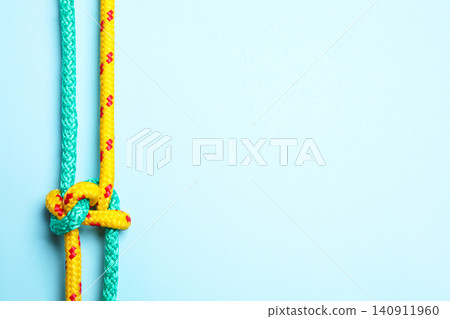Top view of colorful ropes tied with knot on light blue background, space for text. Unity concept Top view of colorful ropes tied with knot on light blue background, space for text. Unity concept 140911960