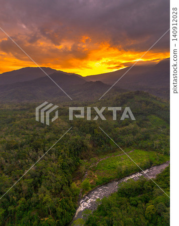 Terraced Rice Fields at Sunrise in Indonesia. Beautiful panoramic view of terraced rice fields surrounded by lush tropical greenery and palm trees Terraced Rice Fields at Sunrise in Indonesia. Beautiful panoramic view of terraced rice fields surrounded by lush tropical greenery and palm trees 140912028