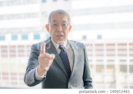 A senior man points and explains from the front. A senior man points and explains from the front. 140912461