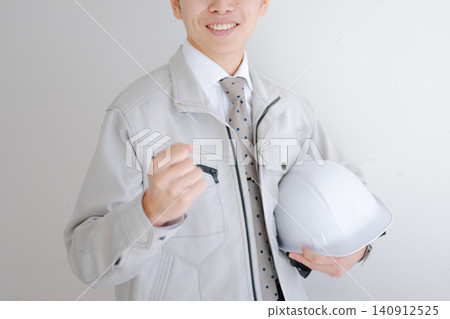 Workers who pose for guts holding a helmet 140912525