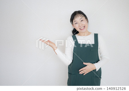 A smiling female staff member guides you with her palm. A smiling female staff member guides you with her palm. 140912526