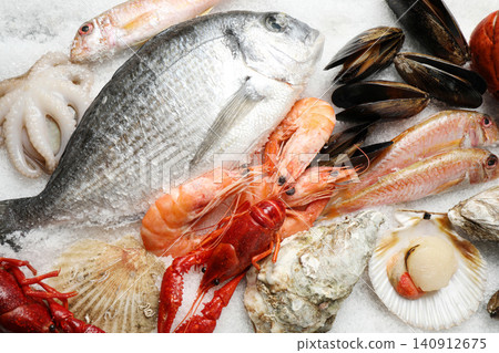Fresh fish and seafood on ice, flat lay Fresh fish and seafood on ice, flat lay 140912675