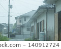 Water is splashing from the sudden downpour onto the roofs of houses. 140912724