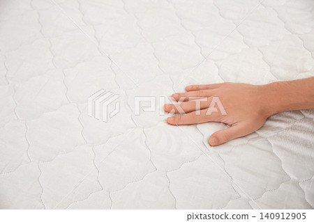 Man checking mattress firmness, closeup. Space for text Man checking mattress firmness, closeup. Space for text 140912905