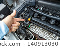 A man's hand pointing to the engine compartment for confirmation. 140913030