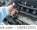 A man's hand pointing to the engine compartment for confirmation. 140913031