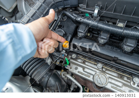 A man's hand pointing to the engine compartment for confirmation. A man's hand pointing to the engine compartment for confirmation. 140913031