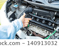 A man's hand pointing to the engine compartment for confirmation. 140913032