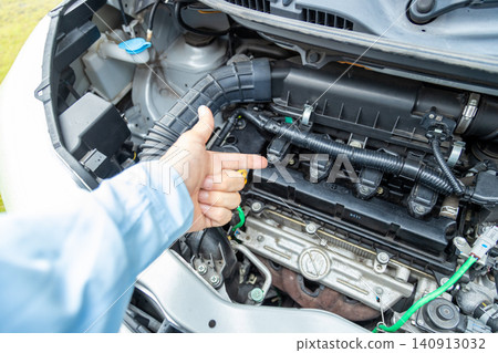 A man's hand pointing to the engine compartment for confirmation. A man's hand pointing to the engine compartment for confirmation. 140913032