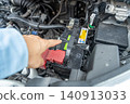 A man's hand pointing to the engine compartment for confirmation. 140913033