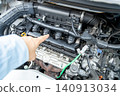 A man's hand pointing to the engine compartment for confirmation. 140913034