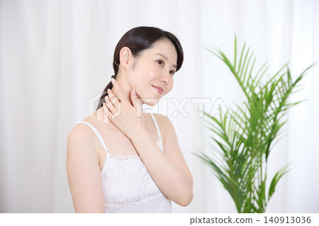A woman smiles, satisfied with her skin after skincare. A woman smiles, satisfied with her skin after skincare. 140913036