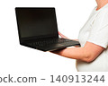 woman holds an open black laptop on an outstretched hand from the side 140913244
