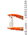 person in orange gloves holds a white spray bottle on a clean white background 140913249