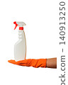 white plastic spray bottle stands on a hand in an orange glove 140913250