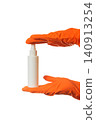 small white spray bottle clamped between hands in orange gloves 140913254