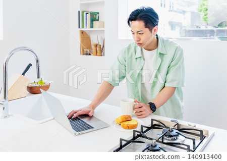 Working remotely while eating breakfast in the kitchen Working remotely while eating breakfast in the kitchen 140913400