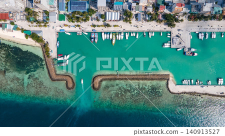 Aerial top view of seaside hotels and jetty with tour boats parking at Maafushi island, Maldives Aerial top view of seaside hotels and jetty with tour boats parking at Maafushi island, Maldives 140913527