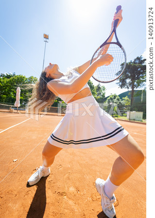 Woman athlete playing tennis on clay court Woman athlete playing tennis on clay court 140913724