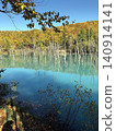 A fantastical landscape where the blue pond, dyed in autumn colors, reflects the withered trees standing there. 140914141