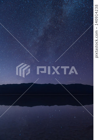 Sierra Nevada mountain silhouette under starry night sky with Milky Way reflection on calm water Sierra Nevada mountain silhouette under starry night sky with Milky Way reflection on calm water 140914238