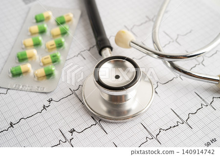 Stethoscope on electrocardiogram ECG with capsule drug, heart wave, heart attack, cardiogram report. Stethoscope on electrocardiogram ECG with capsule drug, heart wave, heart attack, cardiogram report. 140914742